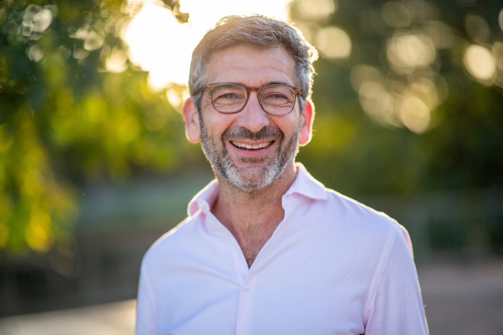 Smiling man with glasses outdoors
